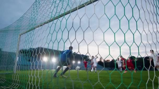 Behind the Net Shot Goalkeeper Standing in Goals Trying To Catch Ball Kicked By Attacking Team but Failing — Stock Video