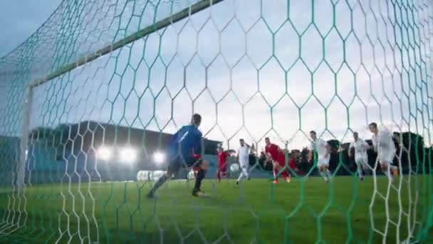 Πίσω από το Net Shot Soccer τερματοφύλακας στέκεται σε στόχους που προσπαθούν να πιάσουν μπάλα κλώτσησε Επιτιθέμενη ομάδα, αλλά αποτυγχάνει — Αρχείο Βίντεο