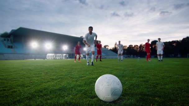 Giocatore di calcio corre e calcia la palla seguita da giocatori avversari — Video Stock