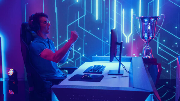 Professional Esport Gamer Compete in a Video Game Playing on Championship Big Stylish Arena. Player Celebrates Victory. International Live Streaming Cyber Gaming Tournament.