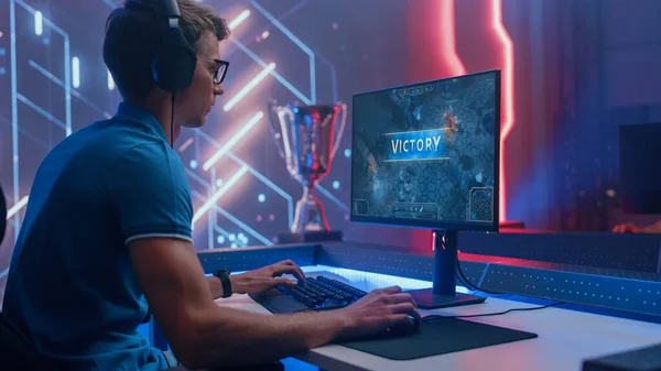 Profissional eSports Gamer ganha em RPG MOBA Mock-up Video Game em seu computador pessoal. Ele está a usar auscultadores. Cyber Gaming elegante sala de néon retro — Fotografia de Stock