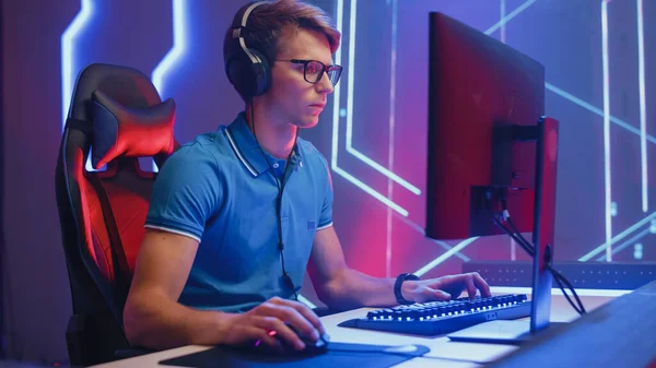 El jugador profesional de eSports juega el videojuego en su computadora personal, levanta las manos para celebrar la victoria después de ganar una ronda. Cyber Gaming Championship. —  Fotos de Stock