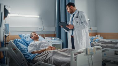 Hastane Koğuşu: Yakışıklı Genç Hasta Yatakta Uyuyor, Hayati değerlerini kontrol ediyor, Bilgi Yazıyor. Covid-18 'den sonra sağlıkçılar yaşlı kadını tedavi ediyor.