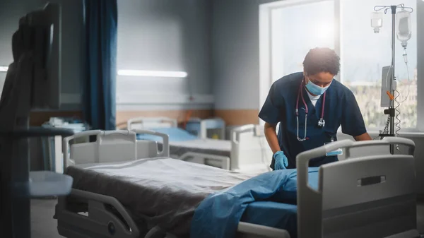 병원 워드 (Hospital Ward): 프로페셔널 블랙 간호사 마스크 (Professional Black Nurse Wearing Face Mask), Cleaning Room After Covid-19 Patients Recover. 코로나 바이러스 가 감염 된 사람들을 치료 한 후의 감염, 불임수술, 소독, 소독 — 스톡 사진