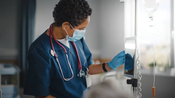 Sjukhus Ward: Professionell svart huvud sjuksköterska bär ansiktsmask Har Checkup av patienter Vitala, Kontrollera hjärtfrekvens Dator, Intravenös eller Iv vätskor droppåse. Vårdgivare Personåterställning — Stockfoto