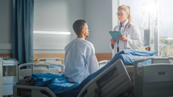 Ospedale Ward: seduto sul letto Caucasico Paziente maschile Ascolta esperto medico femminile che spiega i risultati dei test, dà consigli, prescrive medicina. Uomo che recupera dopo l'intervento chirurgico riuscito, malattia — Foto Stock