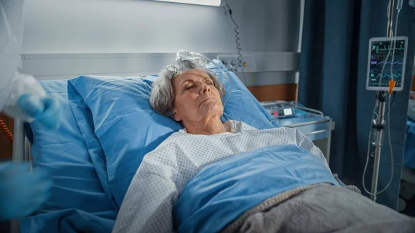 Hospital Ward: Portret van mooie oudere vrouw slapen in bed, volledig herstellen na ziekte en succesvolle chirurgie. Senior vrouw dromen van haar familie, vrienden, gelukkig leven — Stockfoto