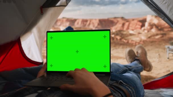 Vista POV Utilizzando il computer portatile con schermo verde in tenda in Canyon — Video Stock
