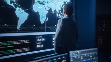 Orta Yaşlı Sakallı Kıdemli Proje Yöneticisi Sinir Ağlı Büyük Ekran 'ın yanında duruyor. Sistem Kontrol ve Telekomünikasyon Ofisi 'nde Profesyonel Bilgisayar Bilimi Mühendisi Çalışması.