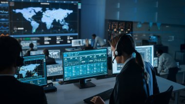 Büyük Dijital Ekrandaki Küresel Haritadan Canlı Ananliz Kaynağı ile Bir Bilgisayar Üzerinde Kadın Uzman Çalışıyor. Çalışanlar, Finansal Borsa Ticareti Bilgileri ve Büyük Verilerle Ekranların Önünde Oturuyorlar.