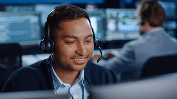 Close Up Portrait of a Joyful Technical Customer Support Specialist Talking on a Headset while Working on a Computer in a Call Center Control Room Komputerkijelző képernyőkkel és adatszerverekkel töltve — Stock Fotó