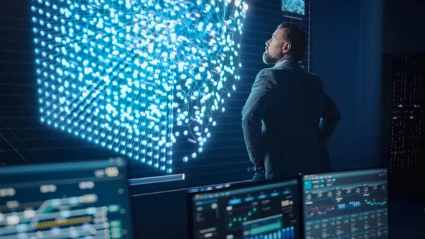 Orta Yaşlı Sakallı Kıdemli Proje Yöneticisi Sinir Ağlı Büyük Ekran 'ın yanında duruyor. Sistem Kontrol ve Telekomünikasyon Ofisi 'nde Profesyonel Bilgisayar Bilimi Mühendisi Çalışması.