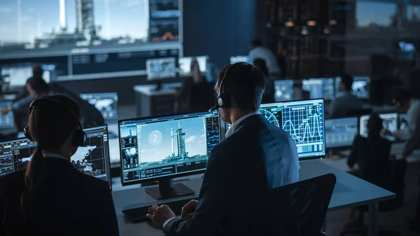 Grupo de pessoas no Centro de Controle de Missão Testemunhe o lançamento do foguete espacial. Funcionários de Controle de Voo sentam-se na frente do computador exibe e monitora a missão tripulada. — Fotografia de Stock