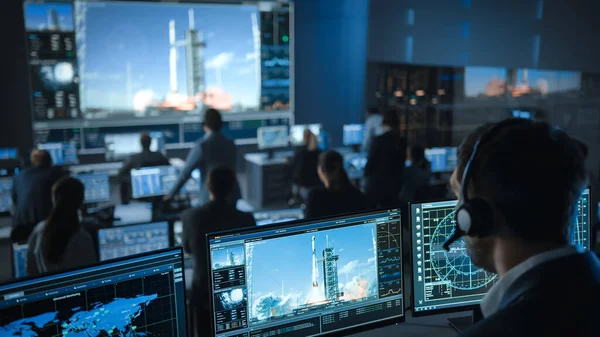 Despachador de vuelos espaciales en el Centro de Control de Misión Testigo de lanzamiento exitoso de cohetes espaciales. Empleados de Control de Vuelo se sientan frente a pantallas de computadora y monitorean la misión tripulada. —  Fotos de Stock