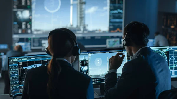 Director de vuelo cuenta atrás los segundos antes del lanzamiento del cohete espacial. Equipo de Control de Misión Testigos Exitoso Despegue. Empleados de Control de Vuelo se sientan frente a computadoras y monitorean la misión. — Foto de Stock