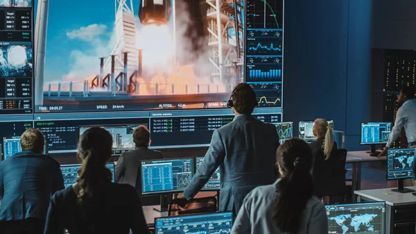 Grupo de Pessoas no Centro de Controle de Missão Testemunha de Sucesso no Lançamento do Foguete Espacial. Funcionários de Controle de Voo Sentam-se em monitores de computador da frente e monitoram a missão tripulada. Emocionado e momento de tensão. — Fotografia de Stock