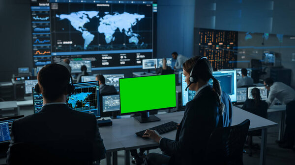 Зеленый экран и онтальная гарнитура, которыми пользуется специалист по работе с клиентами. Команда инженеров работает в зале управления и мониторинга с большими дисплеями