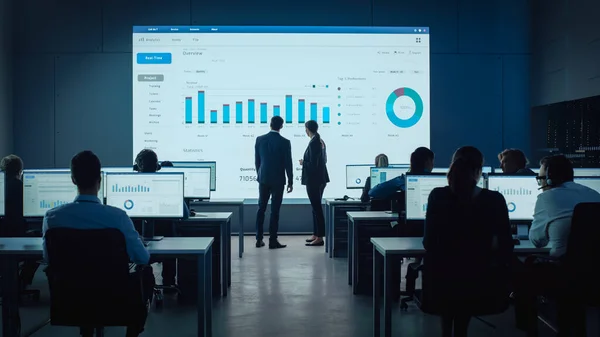 Zwei Händler treffen sich in einem modernen Monitoring-Büro mit Analytik-Feed auf einem großen digitalen Bildschirm. Überwachungsraum mit Maklern und Finanzspezialisten sitzen vor Computern. Kollegen reden. — Stockfoto