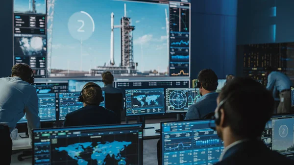 Grupp av människor i Mission Control Center räknar ner sekunderna innan Space Rocket sjösättning. Flygkontroll Anställda sitter i Front Computer visar och övervaka bemanningsuppdraget. — Stockfoto