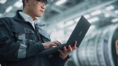 Fabrikada Dizüstü bilgisayarda çalışan Endüstriyel Mühendis