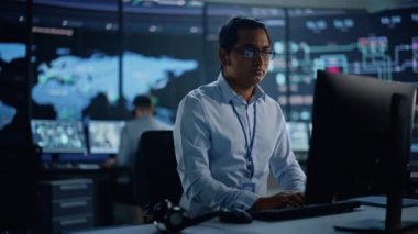 Uzman, monitör odasında kulaklıkla konuşuyor.