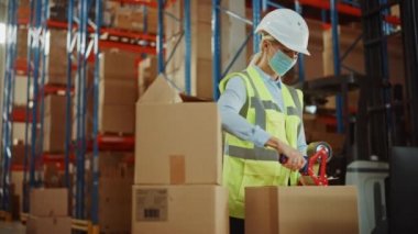 Büyük Depo 'da Yüzü Maskeli Kadın İşçi, Mühürleme Bantlı Karton Kutuyu Kapatıyor
