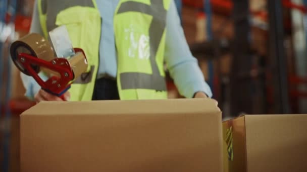 In Big Warehouse vrouwelijke werknemer zegels Kartonnen doos met afdichting tape Dispenser — Stockvideo