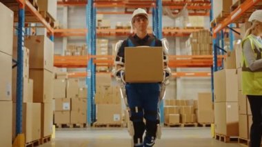 Exoskeleton Takım Elbiseli Geleceğin Modern Depo İşçisi Karton Kutuyu Taşıyor