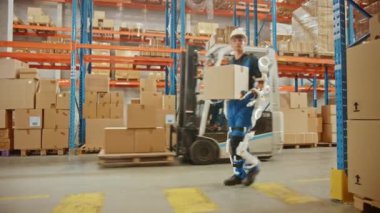 Exoskeleton Takım Elbiseli Geleceğin Modern Depo İşçisi Karton Kutuyu Taşıyor