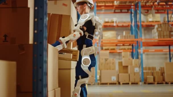 Futurystyczny Nowoczesny Pracownik Magazynu z Exoskeleton Suit Przenosi paletę z kartonowymi pudełkami — Wideo stockowe