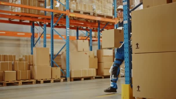 Футуристичний сучасний склад Працівник з Exoskeleton костюм переміщує картонну коробку — стокове відео