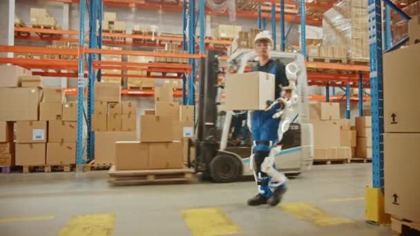 Футуристический современный работник склада с экзоскелетоном двигает картонную коробку — стоковое видео