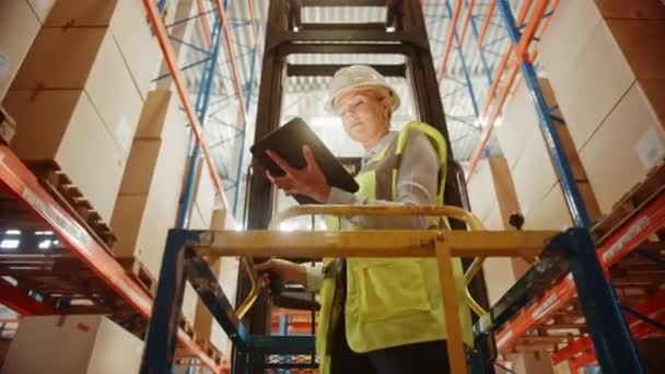 Big Warehouse Female Worker utilizza il computer tablet digitale mentre Beining sollevato dal carrello elevatore — Video Stock