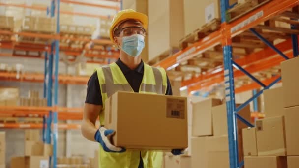 Big Warehouse Worker nosící masku na obličej nese kartónovou krabici — Stock video
