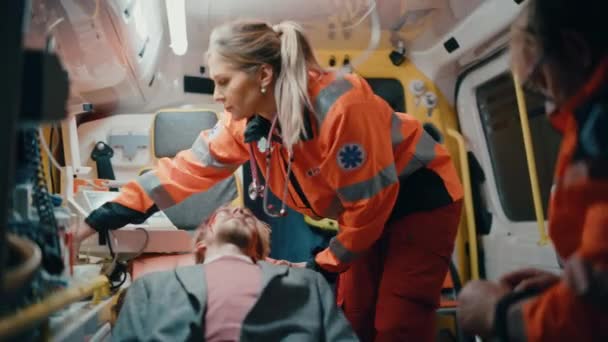 Mentősök Orvosi segítséget nyújtanak a betegnek mentőben — Stock videók