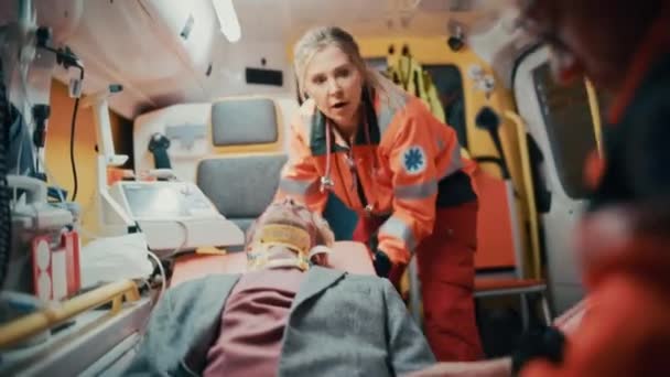 Paramedicinere, der yder lægehjælp til patienter i ambulance – Stock-video