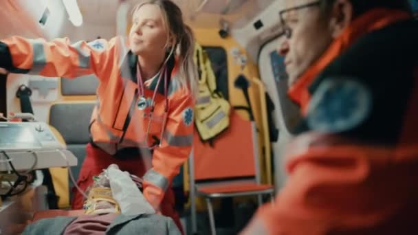 Sjukvårdspersonal som ger medicinsk hjälp till patienter i ambulans — Stockvideo