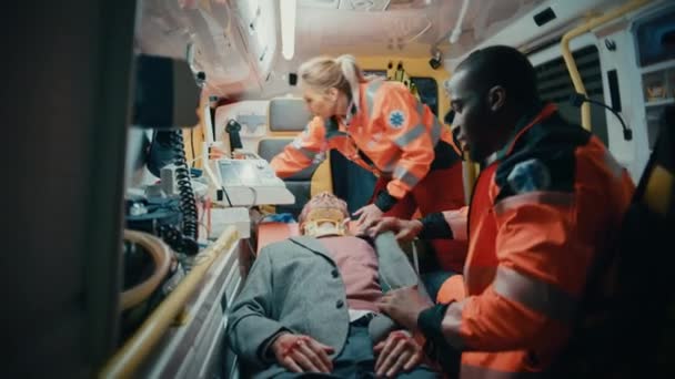 Sjukvårdspersonal som ger medicinsk hjälp till patienter i ambulans — Stockvideo