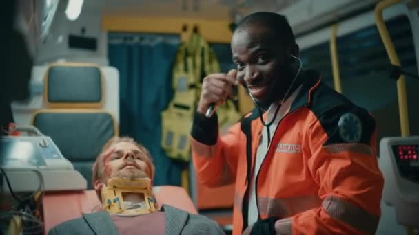 Glada paramedisk ger tummar upp i ambulans med patienten — Stockvideo