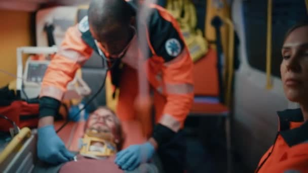 Paramedisk användning av stetoskop på patient i ambulans — Stockvideo