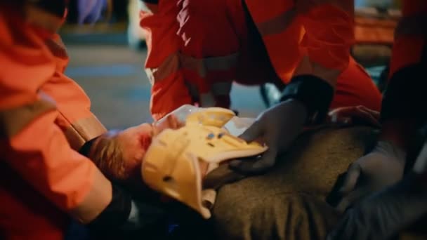 Los paramédicos brindan ayuda médica a un joven acostado en una calle — Vídeos de Stock