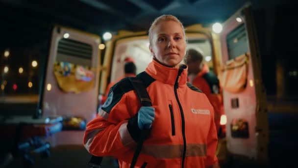 Kvinnligt paramediskt porträtt bredvid ambulans — Stockvideo