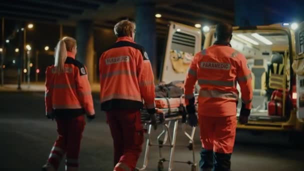 Paramédicos trayendo al paciente dentro de la ambulancia en la camilla — Vídeos de Stock