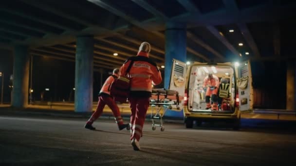 Paramédicos trayendo al paciente dentro de la ambulancia en la camilla — Vídeos de Stock
