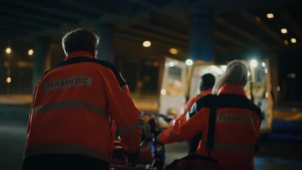 Ensihoitajat tuovat potilaan sisälle ambulanssin paareilla — kuvapankkivideo