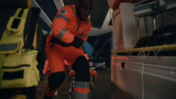 Sanitäter bringen Patient auf Trage in Rettungswagen — Stockvideo