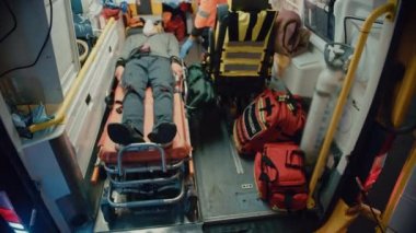 Sağlık görevlileri hastayı ambulanstan sedyeyle çıkarıyorlar.