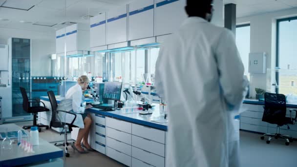 Medizinisches Labor mit arbeitenden Wissenschaftlern — Stockvideo