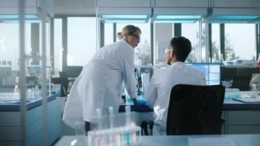 Bilgisayar ve Mikroskop üzerinde çalışan Tıbbi Araştırma Laboratuvarı Bilim Adamları