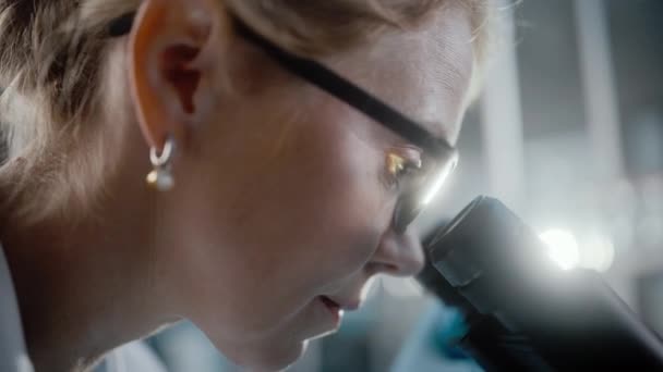 Медицинская исследовательская лаборатория Ученый ищет под микроскопом — стоковое видео